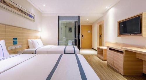 a hotel room with two beds and a flat screen tv at City Comfort Inn Beihai RT-Mart High Speed Railway Station in Beihai