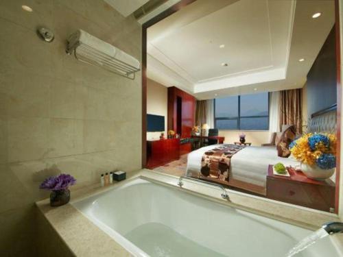 a large bathroom with a tub and a bed at New Century Hotel Putuo Zhoushan in Zhoushan