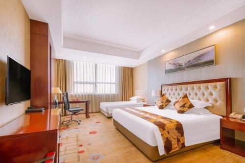 a hotel room with a large bed and a television at New Century Hotel Putuo Zhoushan in Zhoushan