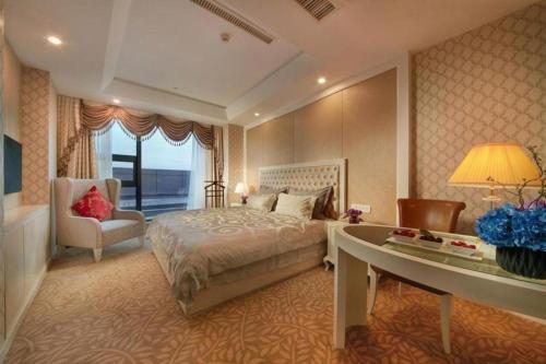 a hotel room with a bed and a desk and a desk at New Century Hotel Putuo Zhoushan in Zhoushan