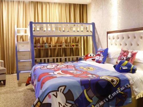 a bedroom with a blue bed with a mickey mouse blanket at New Century Hotel Putuo Zhoushan in Zhoushan