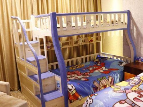 a bunk bed with a blue ladder in a bedroom at New Century Hotel Putuo Zhoushan in Zhoushan