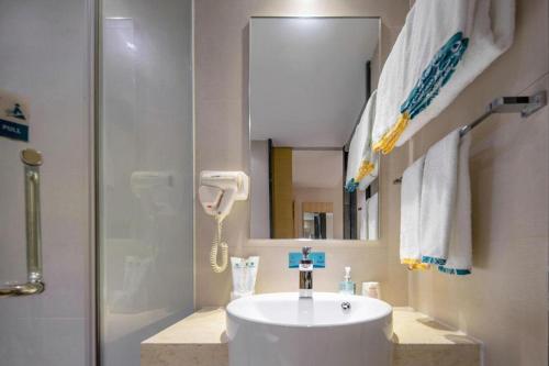 a bathroom with a sink and a shower at City Comfort Inn Beihai RT-Mart High Speed Railway Station in Beihai