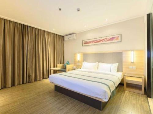 a bedroom with a large bed in a hotel room at City Comfort Inn Beihai RT-Mart High Speed Railway Station in Beihai