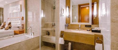 a bathroom with a shower and a sink and a tub at New Century Hotel Putuo Zhoushan in Zhoushan
