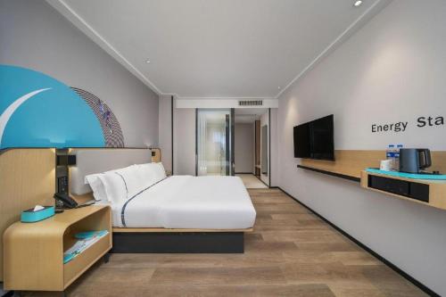 pokój hotelowy z łóżkiem i telewizorem w obiekcie City Comfort Inn Dongguan Humen Wanda High-speed Railway Station Beizha w mieście Dongguan