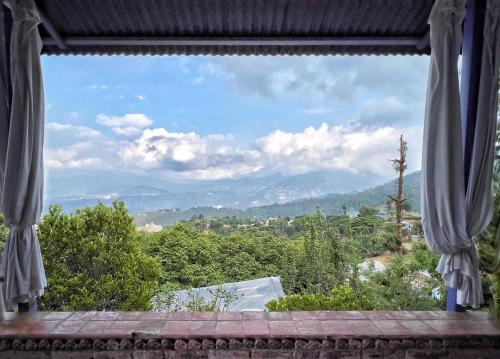 a window with a view of the mountains at Joy Source Resort in Kathmandu