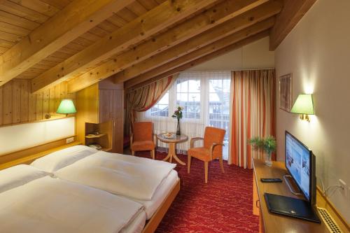 ツェルマットにあるホテル シェミニの大きなベッドとテーブルが備わるホテルルームです。