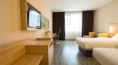 a hotel room with two beds and a desk at City Comfort Inn Wuhan High Speed Railway Station in Wuhan