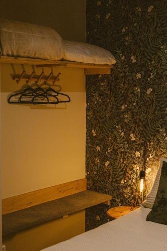 a bedroom with a bed and a wall with flowers at THE BIRD'S NEST - Secluded getaway! in Christchurch