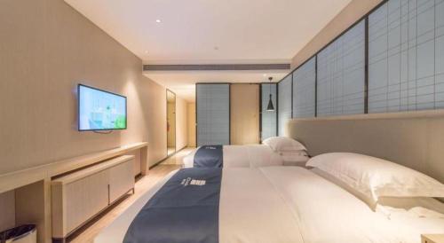 Postel nebo postele na pokoji v ubytování Echarm Hotel Yangjiang Baili Plaza
