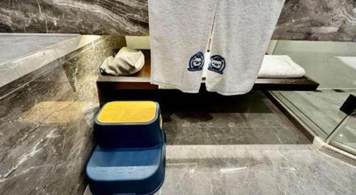 a bathroom with a bench with a towel and a stool at International Conference Hotel Nanjing in Nanjing