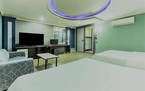 a hotel room with a bed and a tv at Hotel Head-One in Uijeongbu