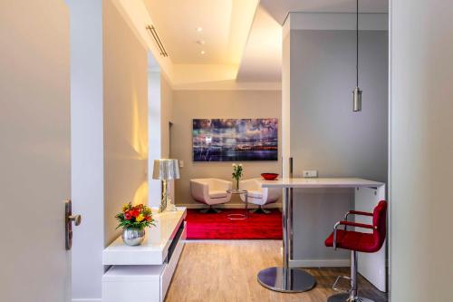 ワイマールにあるAmalienhof Serviced Apartmentsのリビングルーム(テーブル、赤い敷物付)
