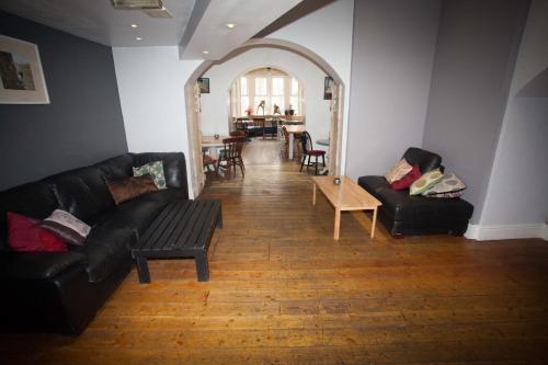 a living room with two black couches and a table at The Heights Bunkhouse in Llanberis