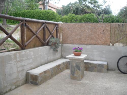 a patio with a bench and a potted plant at Appartamento MareMontagna in Cardedu