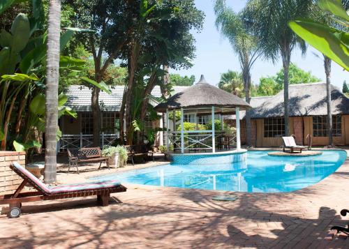 een zwembad met een prieel en een resort bij Summerview Guest Lodge in Johannesburg