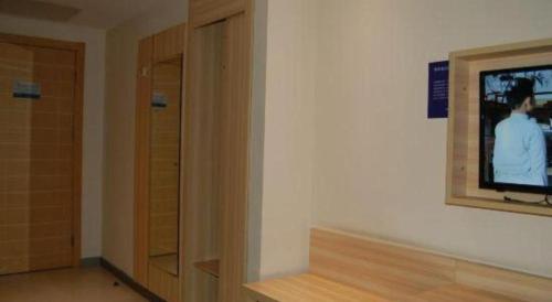 a room with a tv on a wall next to a door at City Comfort Inn Foshan Shunde Daliang Qinghui Garden Xinsong in Shunde
