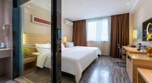 a hotel room with a large white bed and a kitchen at City Comfort Inn Foshan Shunde Daliang Qinghui Garden Xinsong in Shunde
