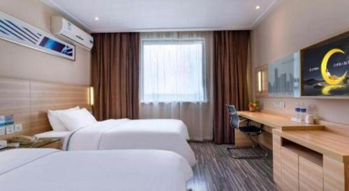 a hotel room with two beds and a desk at City Comfort Inn Foshan Shunde Daliang Qinghui Garden Xinsong in Shunde