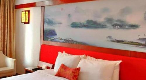 a large painting above a bed in a hotel room at Golden Lustre Hotel in Shenzhen