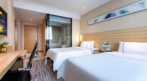 a hotel room with two beds and a desk at City Comfort Inn Foshan Shunde Daliang Qinghui Garden Xinsong in Shunde