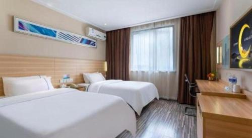 a hotel room with two beds and a window at City Comfort Inn Foshan Shunde Daliang Qinghui Garden Xinsong in Shunde