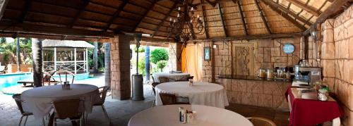 a restaurant with tables and chairs and a pool at Summerview Guest Lodge in Johannesburg