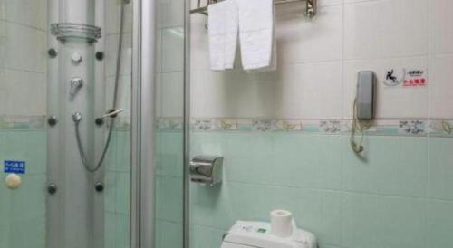 a bathroom with a shower and a toilet and a phone at Golden Lustre Hotel in Shenzhen