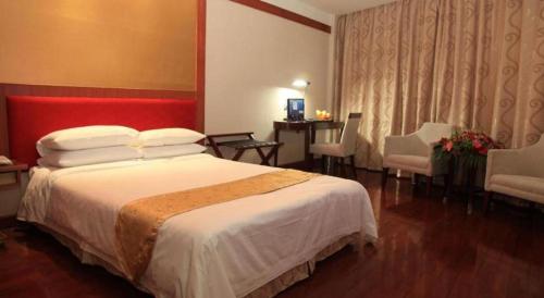 a hotel room with a large bed and a desk at Golden Lustre Hotel in Shenzhen