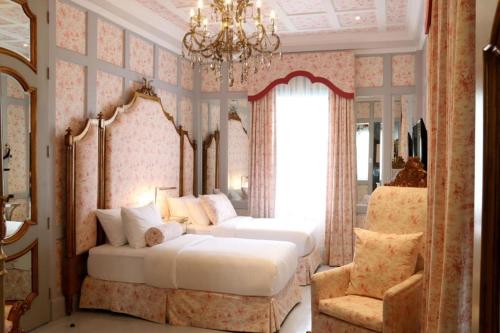 バギオにあるKamiseta Hotelのベッド2台とシャンデリアのある寝室