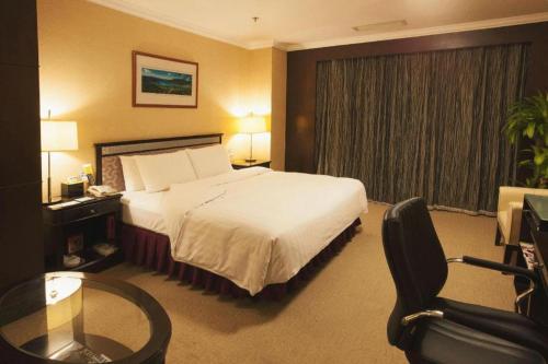 a hotel room with a bed and a glass table at Changchun Zhuozhan Days Hotel in Changchun
