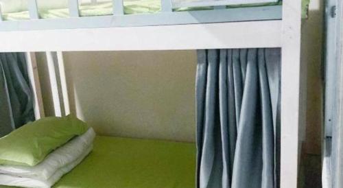 a bedroom with a bunk bed with a green floor at Beihai forget dust International Youth Hostel in Beihai