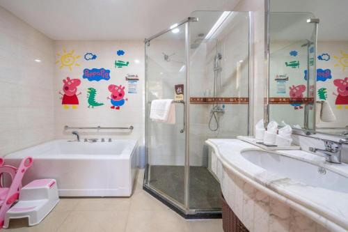 a bathroom with a shower and a tub and a sink at Nanning Yongzhou Hotel in Nanning