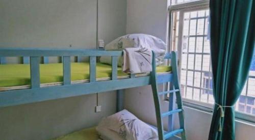 two bunk beds in a room with a window at Beihai forget dust International Youth Hostel in Beihai