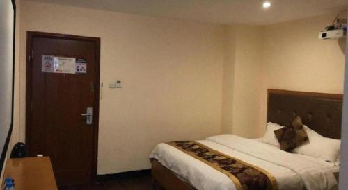 a hotel room with a bed and a door at shenzhen kaixin Hotel in Shenzhen