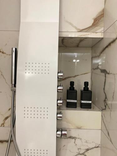 a bathroom with a shower with two complimentary bottles on a shelf at Casa Moniga 2-Residenze Lizzeri in Moniga