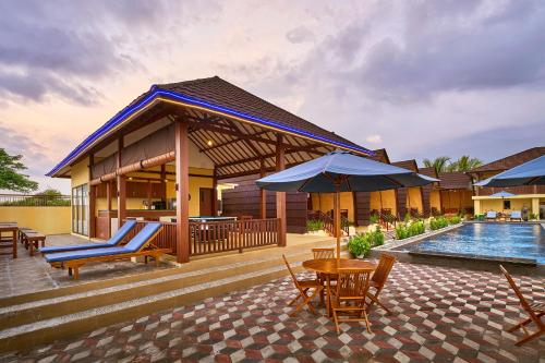 a house with a pool and a patio with chairs and umbrellas at Bayview Beach Resort East Lombok in Labuan Lombok
