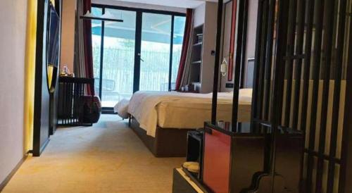 a hotel room with a bed and a balcony at Yuan Culture Hotel Shenzhen World Shajing in Shenzhen