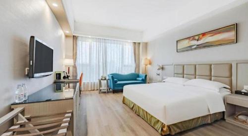 a hotel room with a large bed and a television at Hefei Parkview Hotel in Hefei