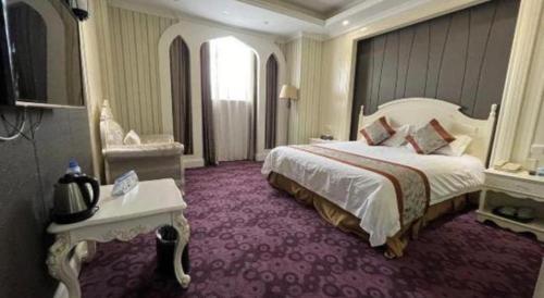 a large hotel room with a large bed and purple carpet at New century Manju Select Hotel Hongqiao Hub National Exhibition Center in Shanghai