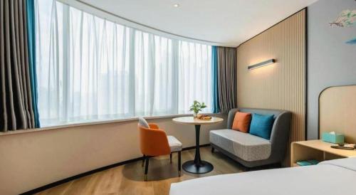 a hotel room with a bed and a table and a chair at City Comfort Inn Nanning Guangxi University in Nanning