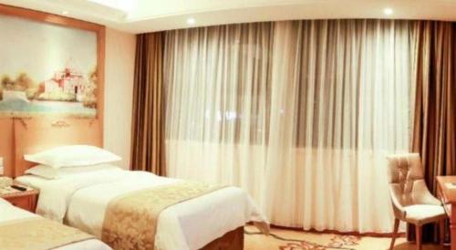 a hotel room with two beds and a window at Vienna Classic Hotel Qingdao Huangdao in Huangdao