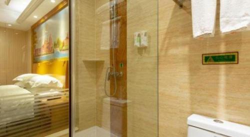 a bathroom with a shower and a toilet at Vienna Classic Hotel Qingdao Huangdao in Huangdao