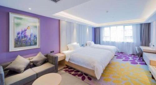a bedroom with a large bed and a couch at Lavande Hotels·Yichang Wanda Plaza in Yichang