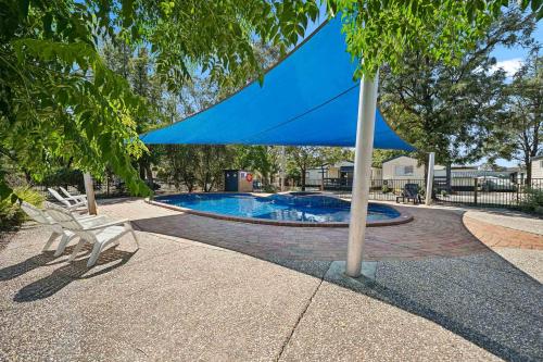 a blue umbrella sitting next to a swimming pool at Wodonga Holiday Park in Wodonga