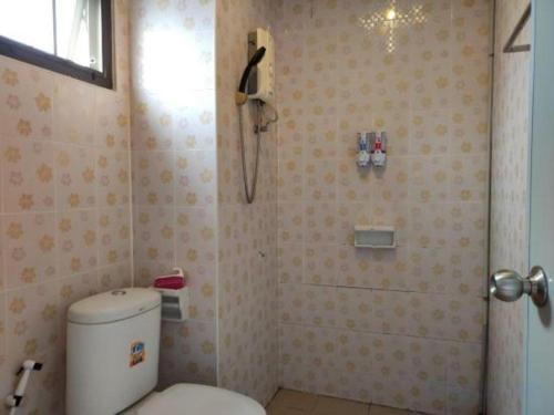a bathroom with a toilet and a phone on the wall at Erawan Place in Mae Sot