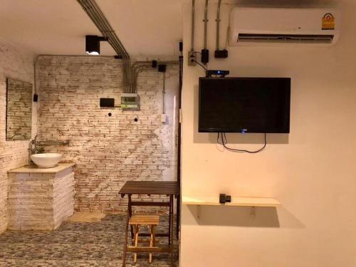 a room with a tv on a wall at The State Resort in Ban Wat Phrik