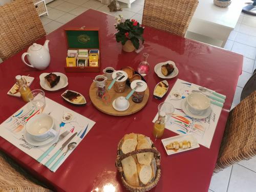 une table rouge avec de la nourriture en haut dans l'établissement CHAMBRE D'HOTES Côté RANCE, à La Ville-ès-Nonais