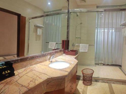 a bathroom with a sink and a large mirror at Jie Hao Royal Hotel in Shenzhen